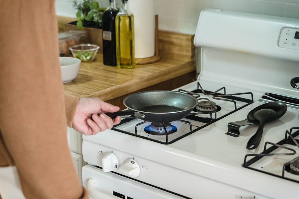 person preparing to cook on gas stove